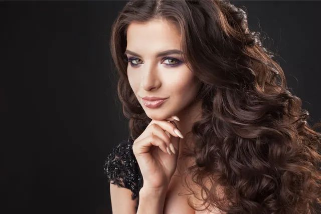 Ragazza con capelli castani con lunghezze ricce