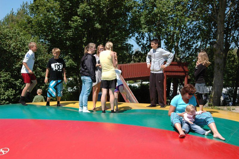 Glade boern hopper paa stor hoppepude paa Vesterlyng Camping paa Sjaelland.