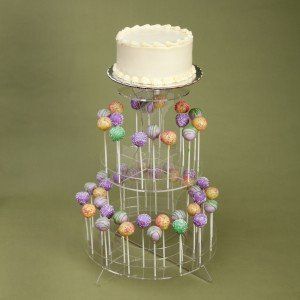 Cake and cake pop stand with frosted cake on top and cake pops arranged in tiers.