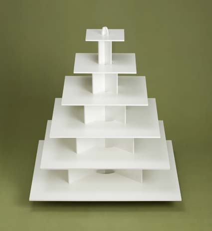 White, tiered cupcake stand on a green background.
