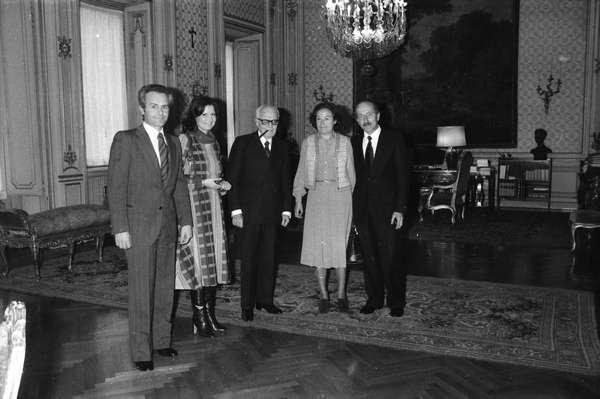 Un gruppo di persone è in piedi in una stanza in una foto in bianco e nero.