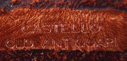 Primo piano di un pezzo di legno con incise le parole castello old antiquari.