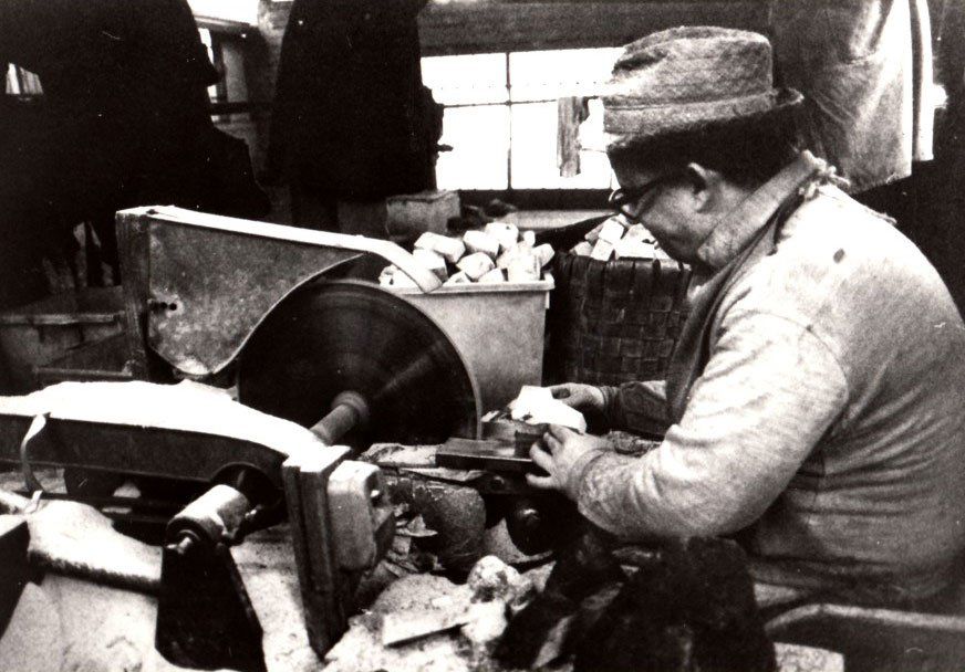 Una foto in bianco e nero di un uomo che lavora su una macchina