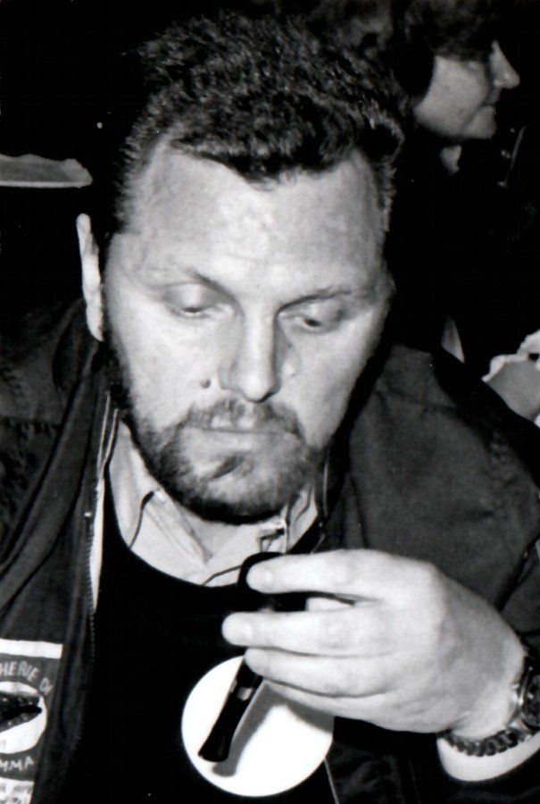 Un uomo con la barba tiene in mano un cellulare