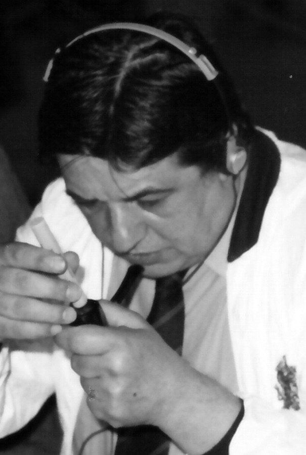 Un uomo in camice bianco e cravatta sta guardando attraverso una lente di ingrandimento