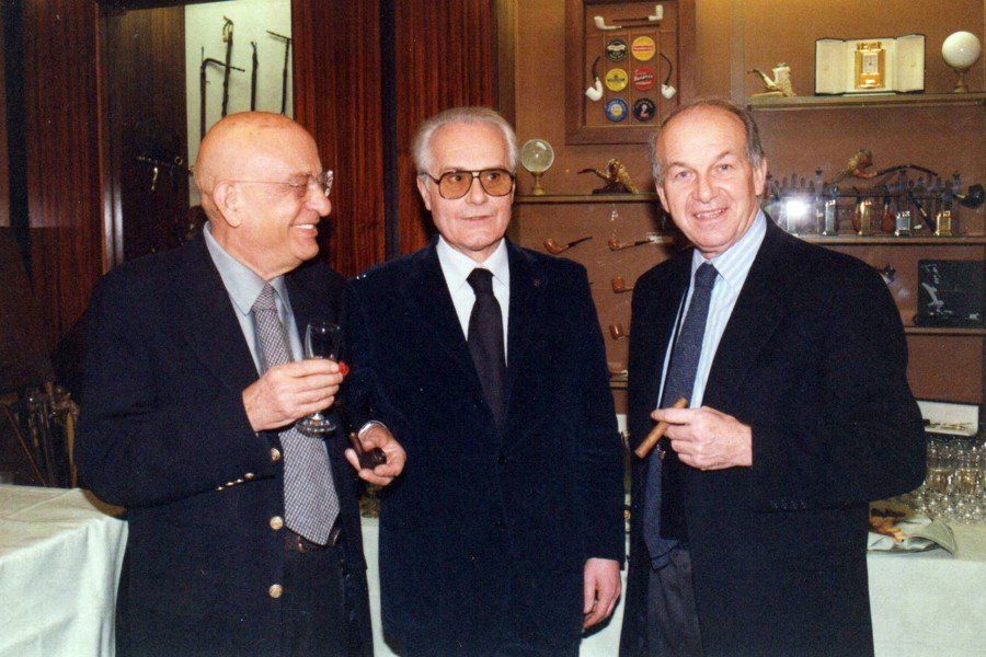 Tre uomini in giacca e cravatta sono in piedi uno accanto all'altro