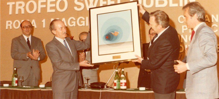 Un gruppo di uomini in piedi davanti a un cartello che dice trofeo
