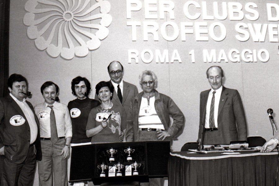 Un gruppo di persone in piedi davanti a un cartello che dice per clubs d trofeo sw roma 1 maggio