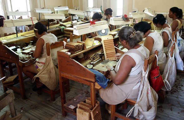 Un gruppo di donne sta producendo sigari in una fabbrica