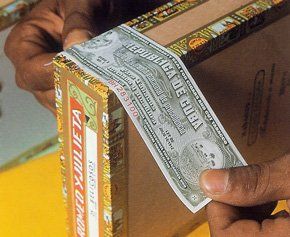 Una persona tiene in mano un pezzo di carta con la scritta Republica de Cuba