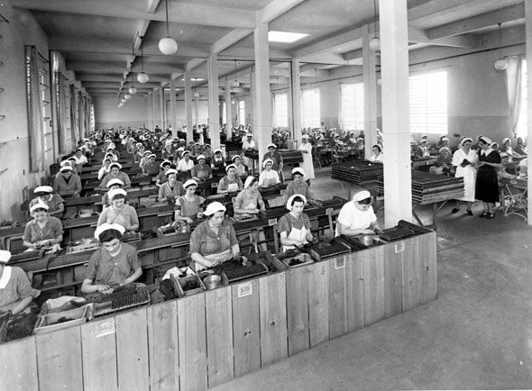 Una foto in bianco e nero di persone che lavorano in una fabbrica
