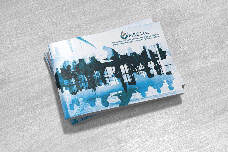 Brochure stack with blue and white graphic on a light wooden surface.