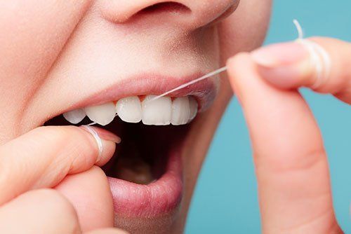 woman flossing her teeth