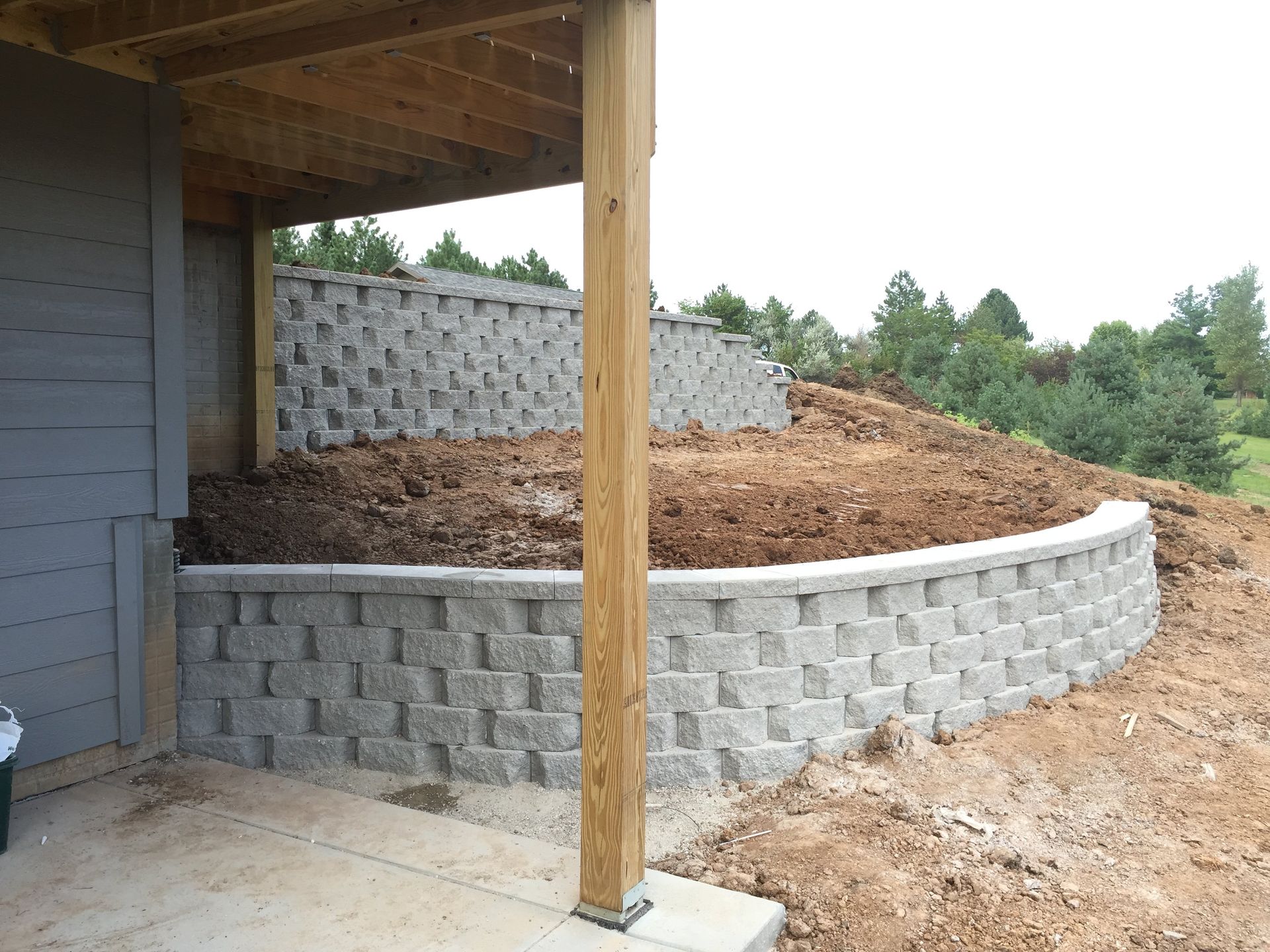 A brick wall with a wooden post underneath it