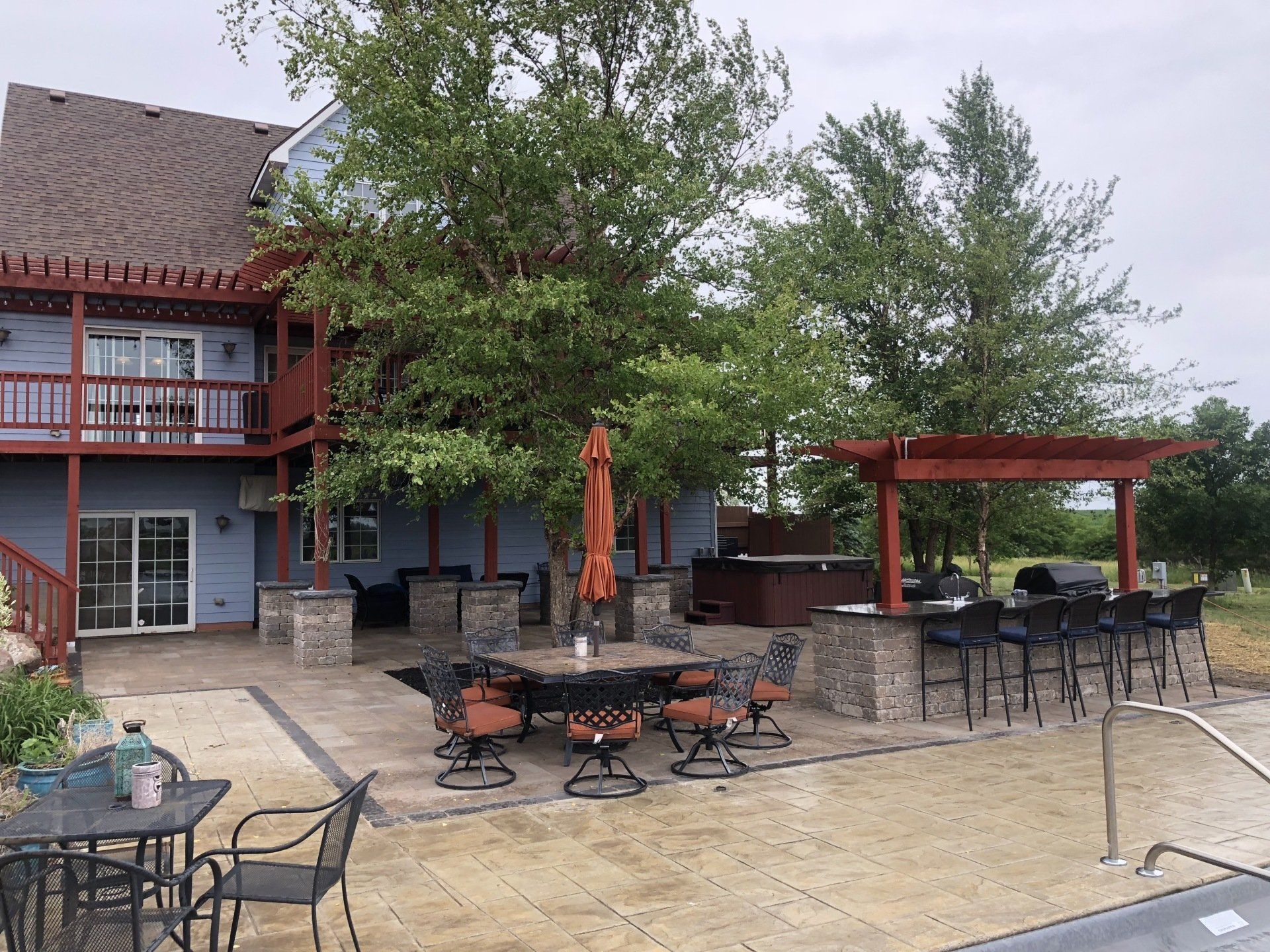 A large house with a large patio area with tables and chairs