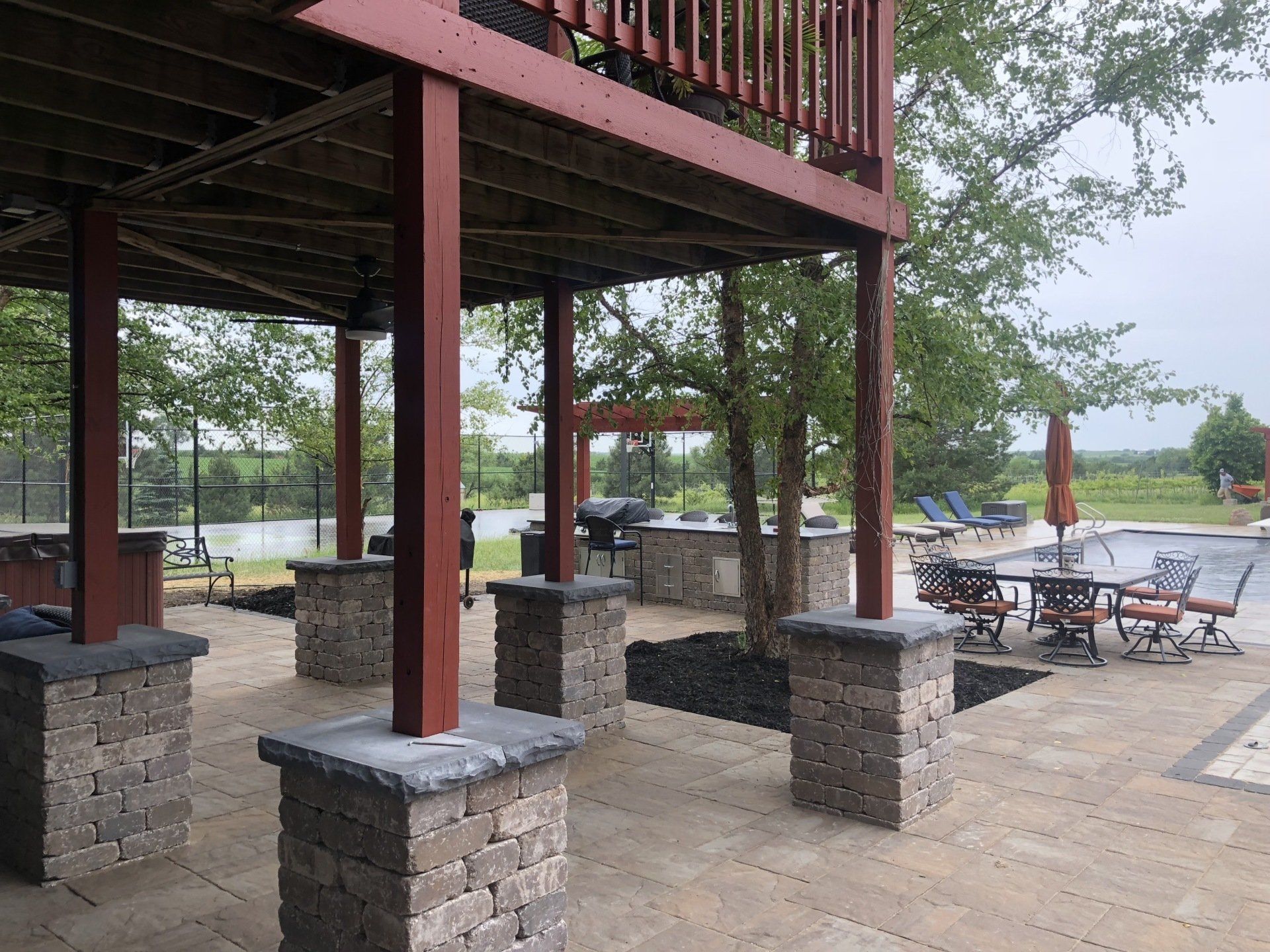 A large patio area with tables and chairs under a deck.