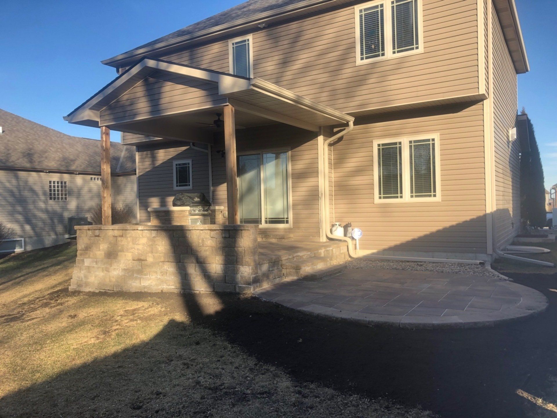 A house with a porch and a patio in front of it.