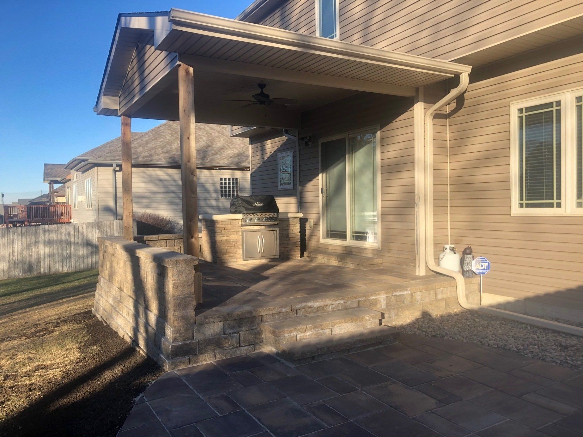A house with a porch and a patio in front of it.