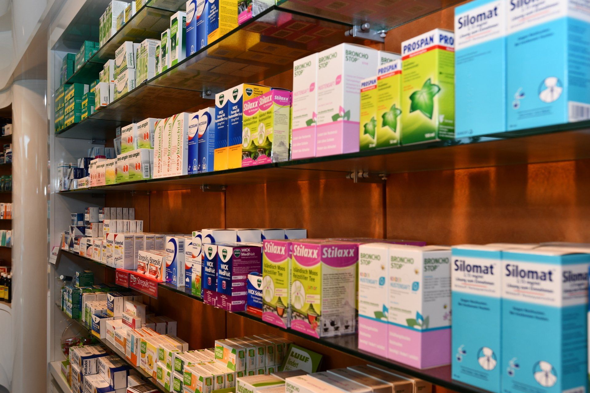 Regale in einer Apotheke, gefüllt mit verschiedenen Medikamentenpackungen.