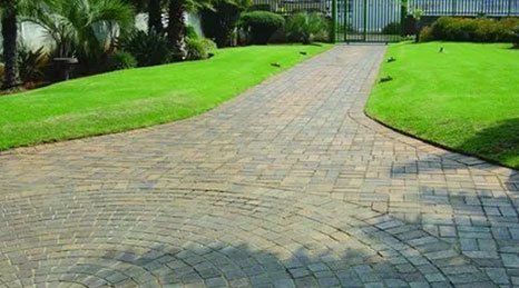 A paved path and patio area with grass either side