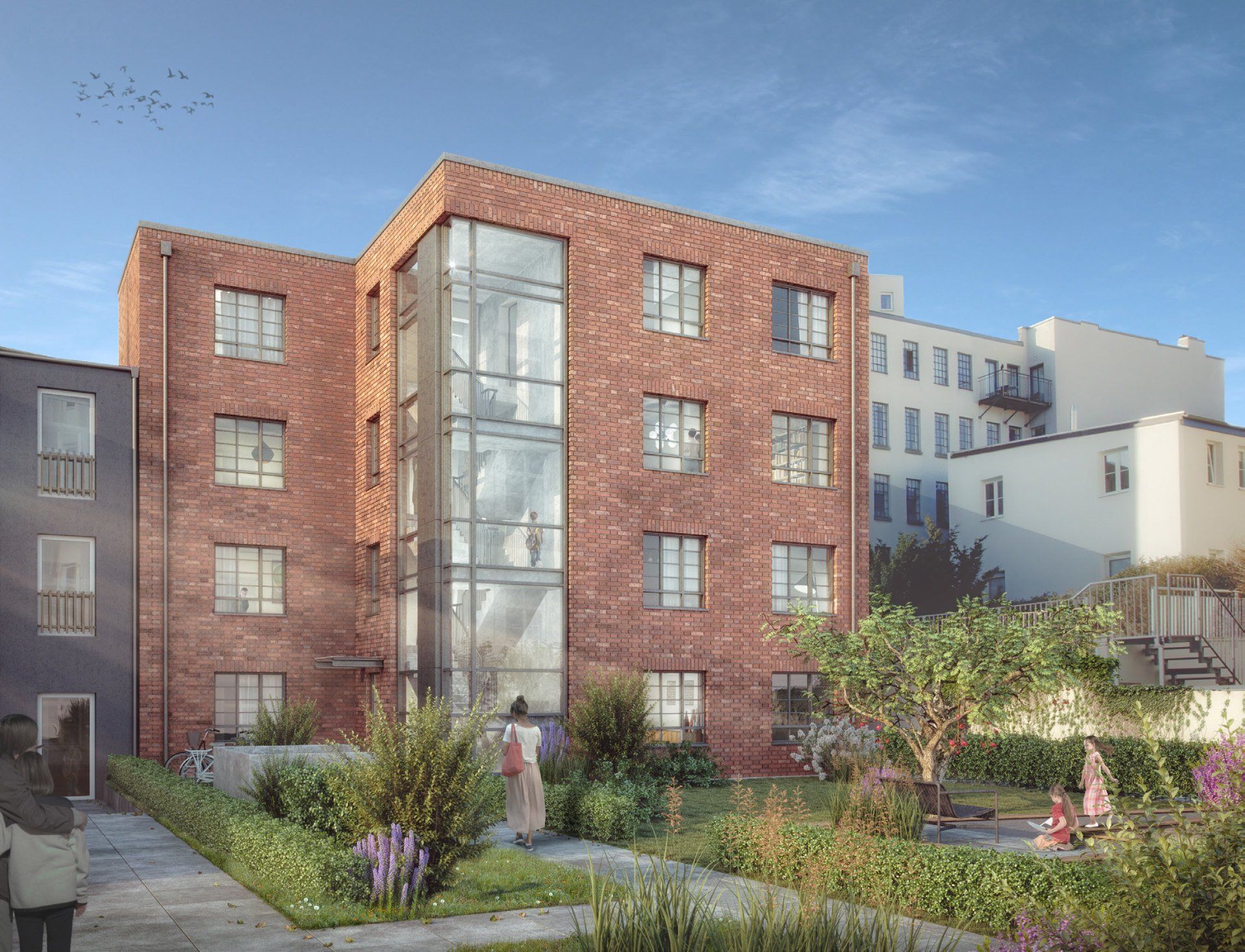Backstein-Apartmentgebäude mit großen Fenstern und einem angelegten Garten unter klarem Himmel