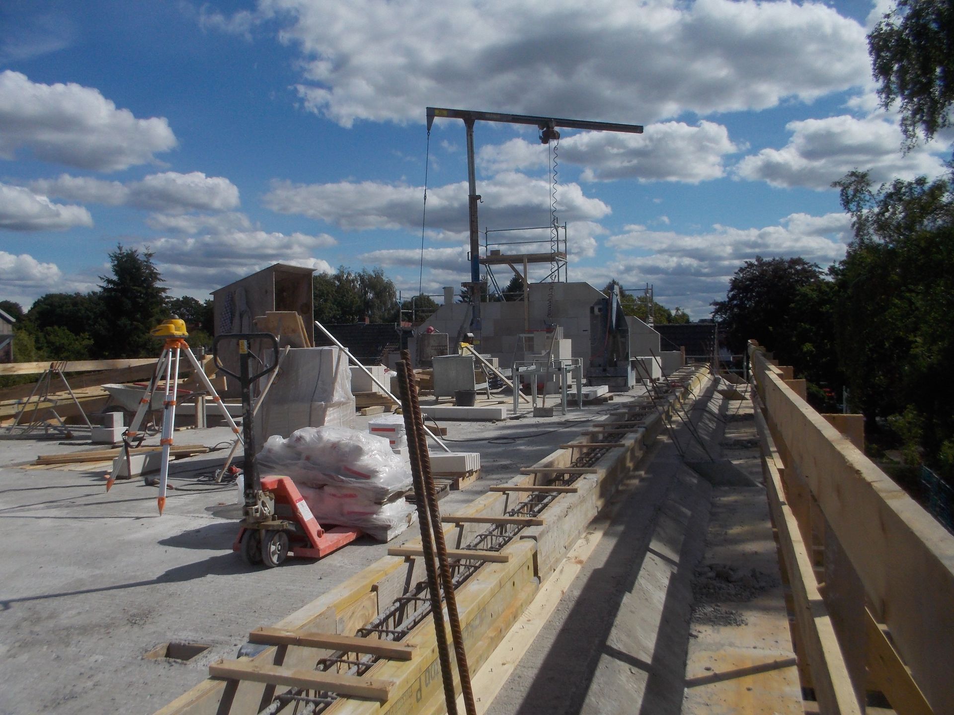 Baustelle mit Betonkonstruktionen, Gerüsten und Geräten unter bewölktem Himmel