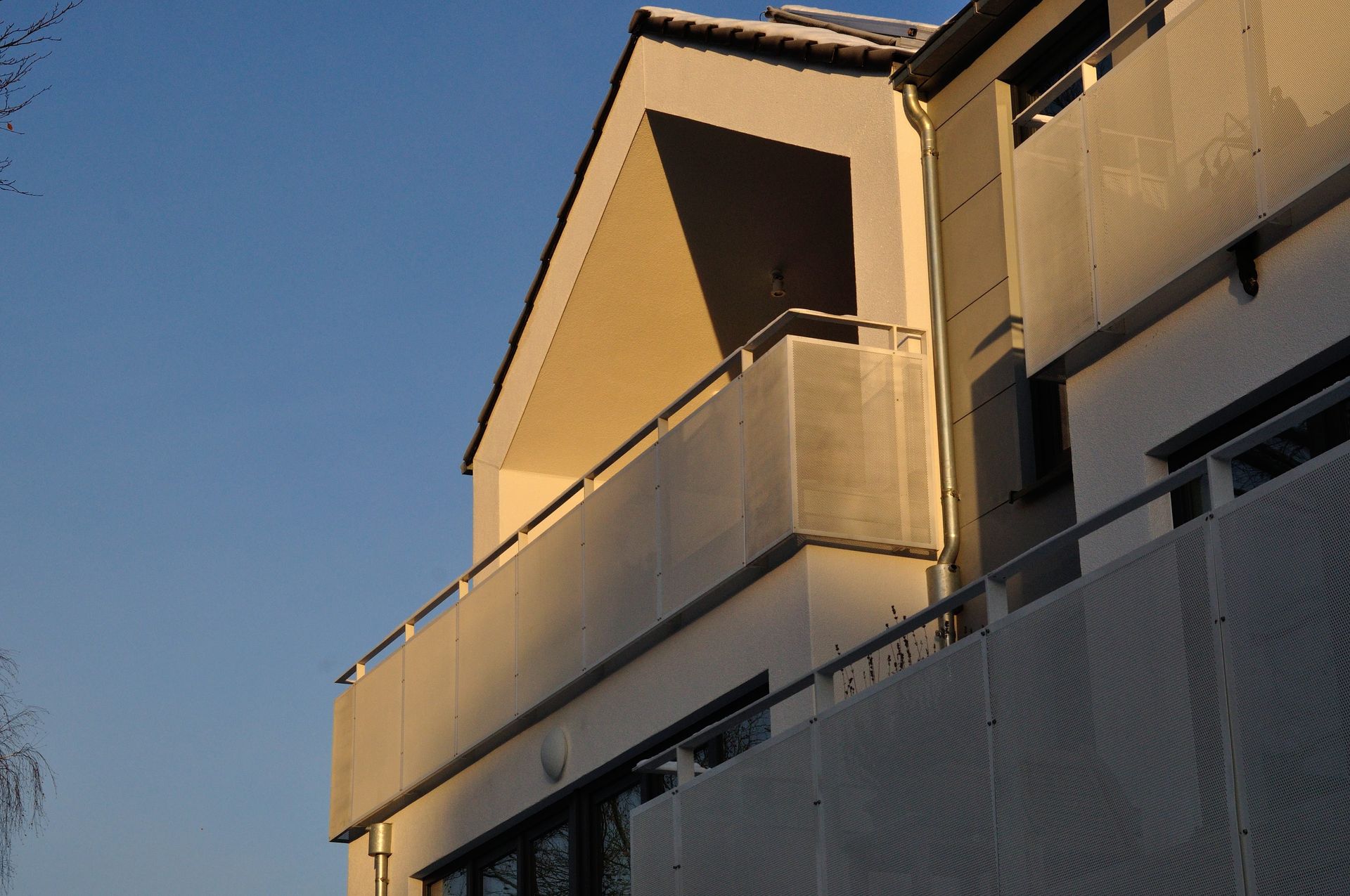 Balkone der Wohnungen im warmen Sonnenlicht vor einem klaren blauen Himmel
