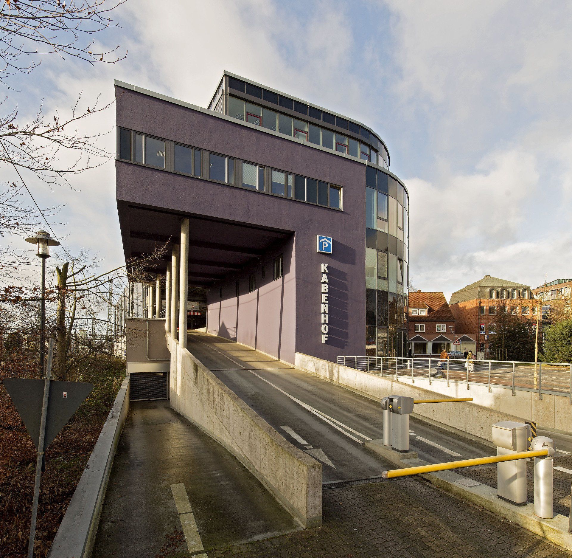 Modernes Gebäude mit einer barrierefreien Rampe und Treppe, von außen betrachtet an einem sonnigen Tag