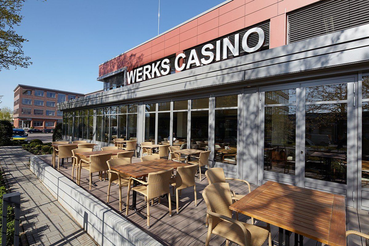 Außenterrasse im Werks Casino mit Korbtischen und -stühlen neben großen Glasfenstern