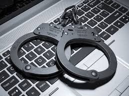 Handcuffs on Laptop — Eau Claire, WI — Cohen Law Offices Handcuffs on Laptop — Eau Claire, WI — Cohen Law Offices