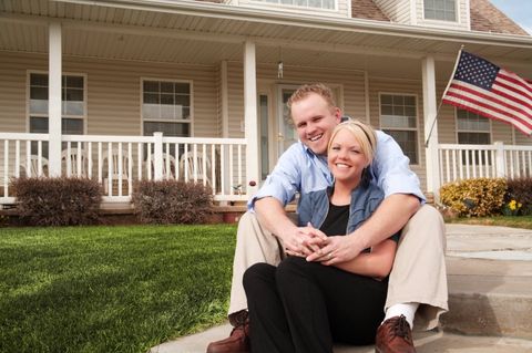 happy couple in front of home