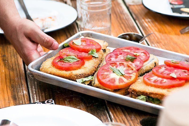 Open toast with fresh tomato and herbs being served – healthy breakfast option in  all day restaurant in Mykonos