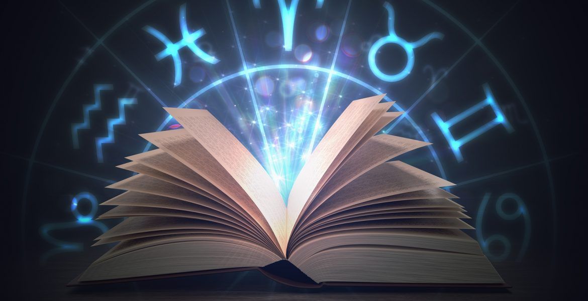 Um livro aberto com um signo do zodíaco ao fundo.