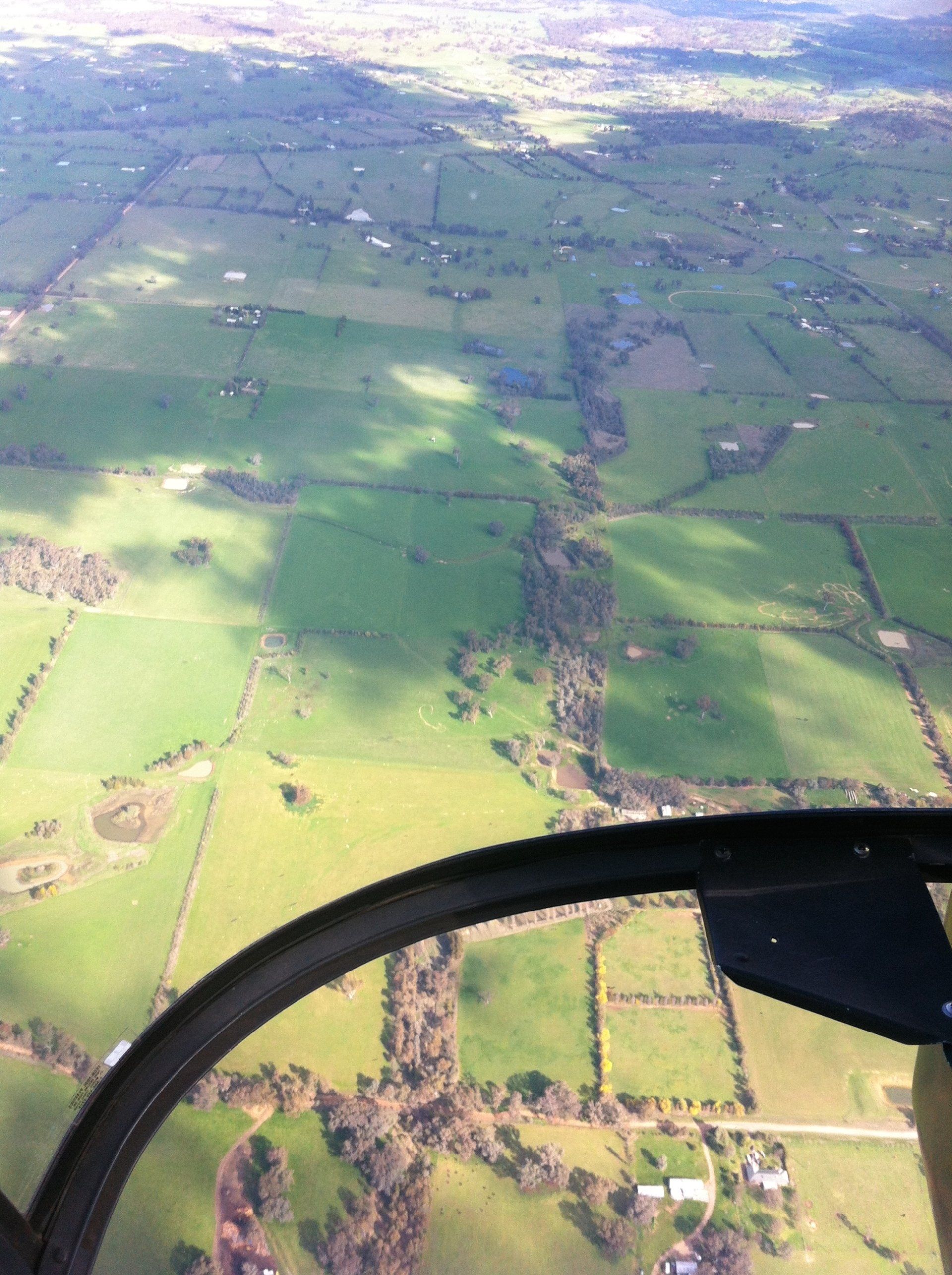 Tapestry of paddocks beneath the clouds.