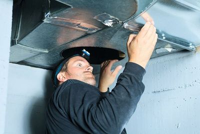Man Checking Air Duct — Waterford Township, MI — Sutton & Son's Mechanical Inc Man Checking Air Duct — Waterford Township, MI — Sutton & Son's Mechanical Inc