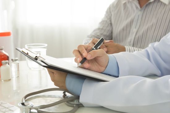 medico che compila un documento