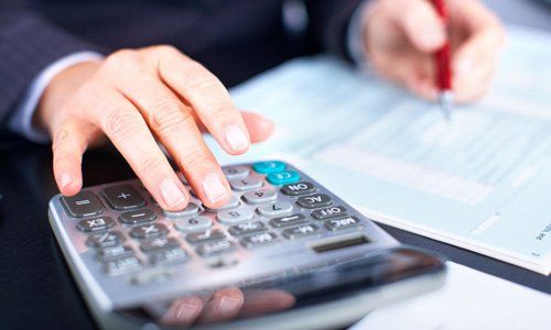 an accountant using calculator for tax calculation