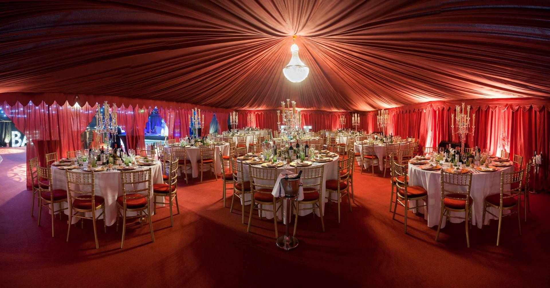 A large room filled with tables and chairs under a tent.