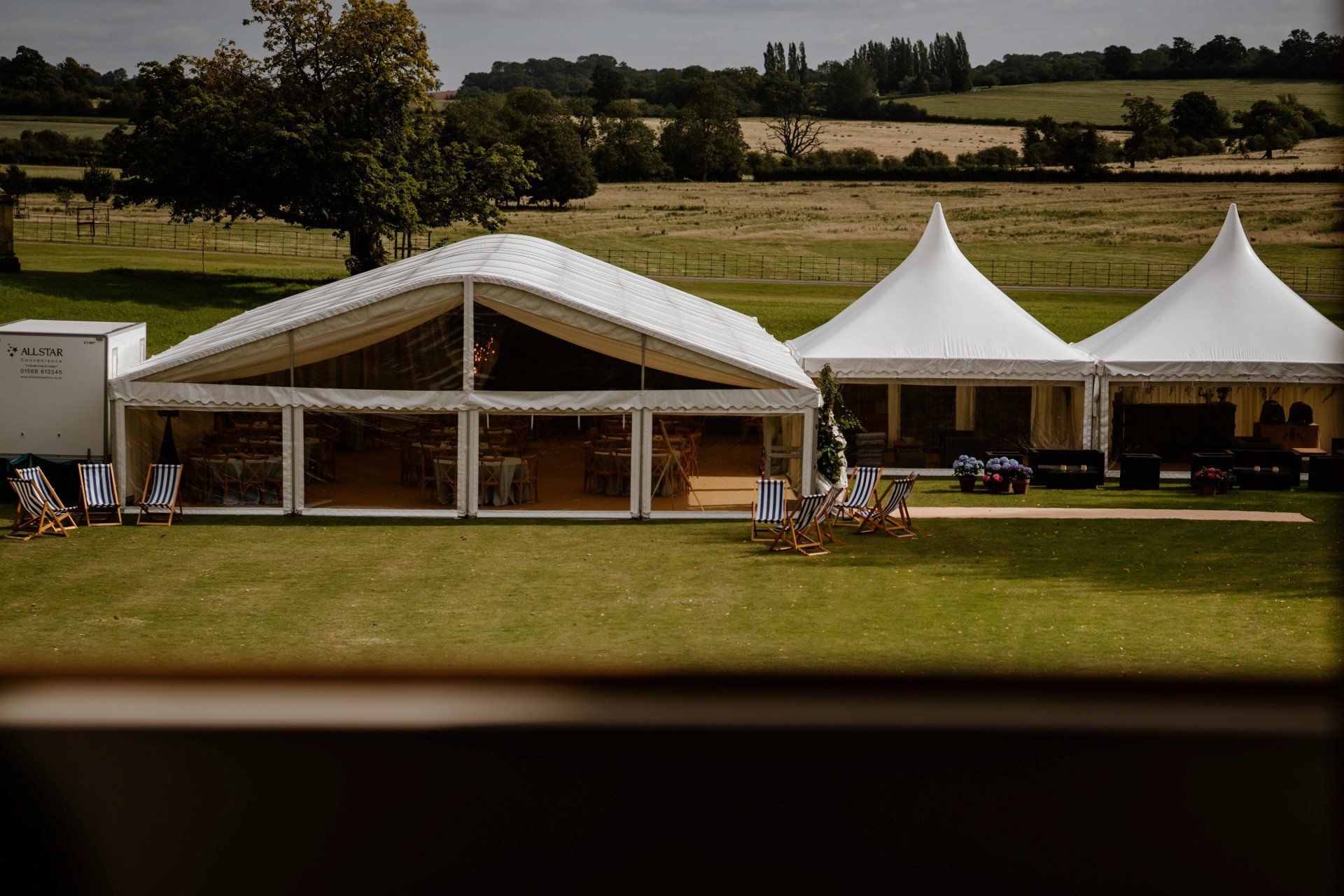 A group of marquees are sitting on top of a lush green field.