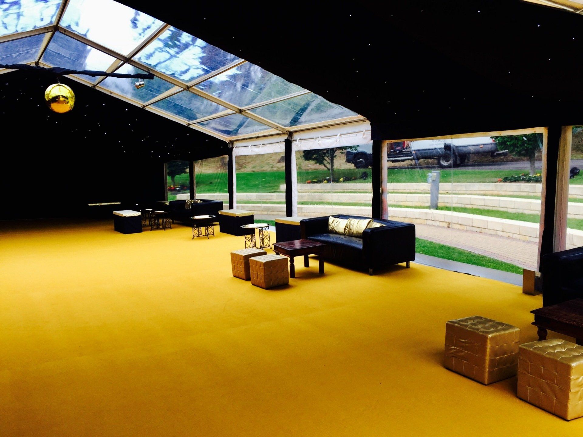 A large room with a clear roof and a lot of furniture