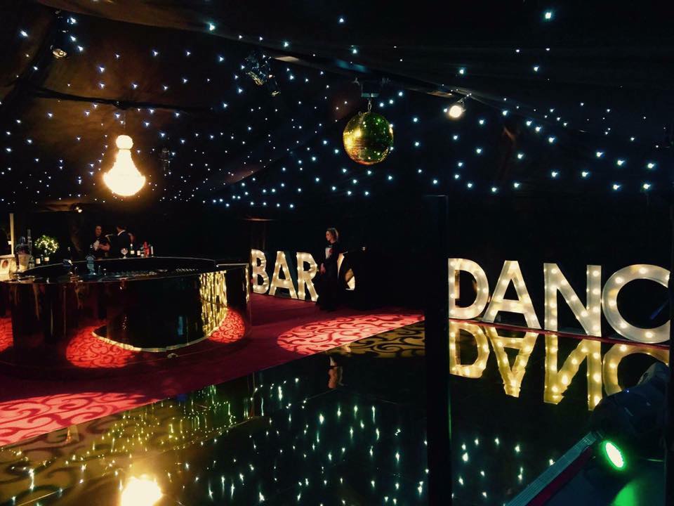 A dance floor in a dark room with lights on the ceiling