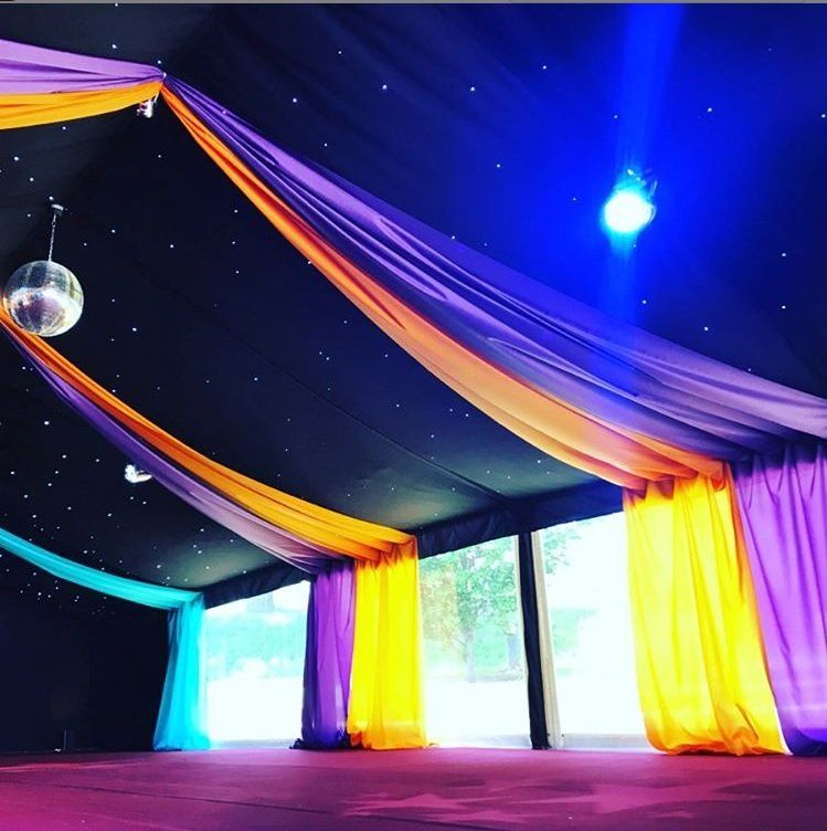 A disco ball hangs from the ceiling of a tent
