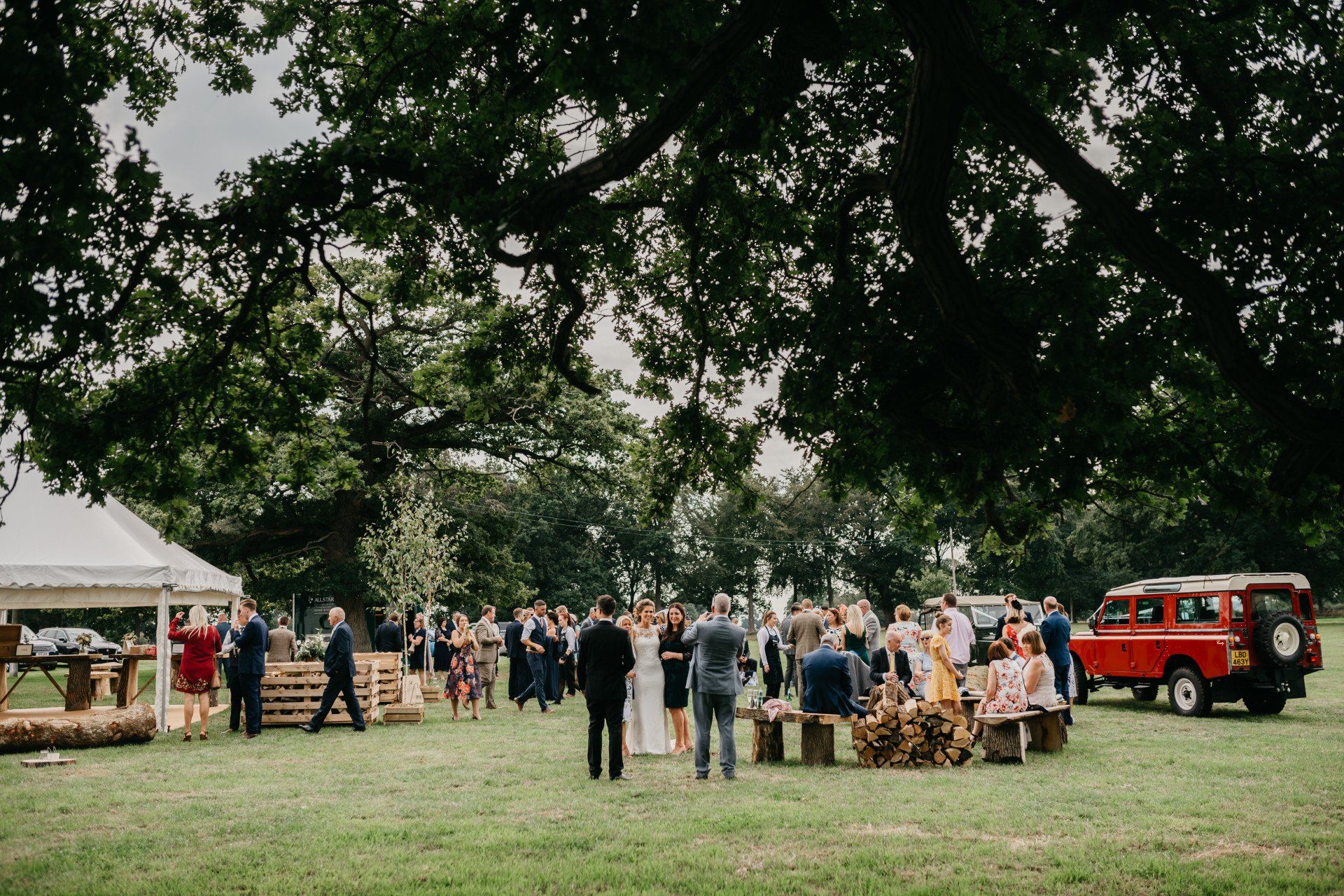 A large group of people are standing in a grassy field.