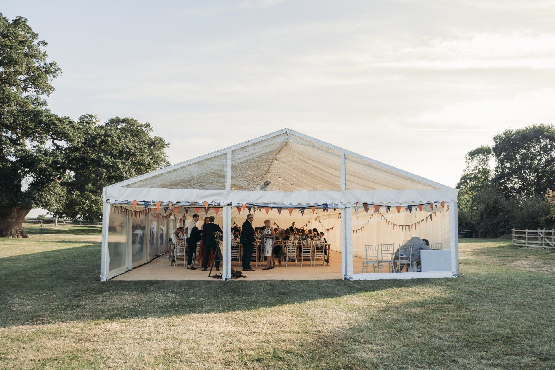 A large white tent is sitting in the middle of a grassy field.