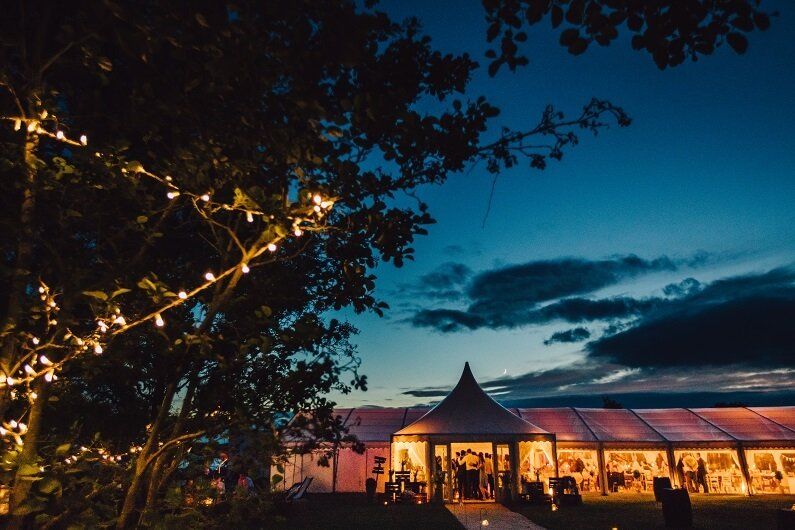 A marquee is lit up at night for a Worcestershire wedding
