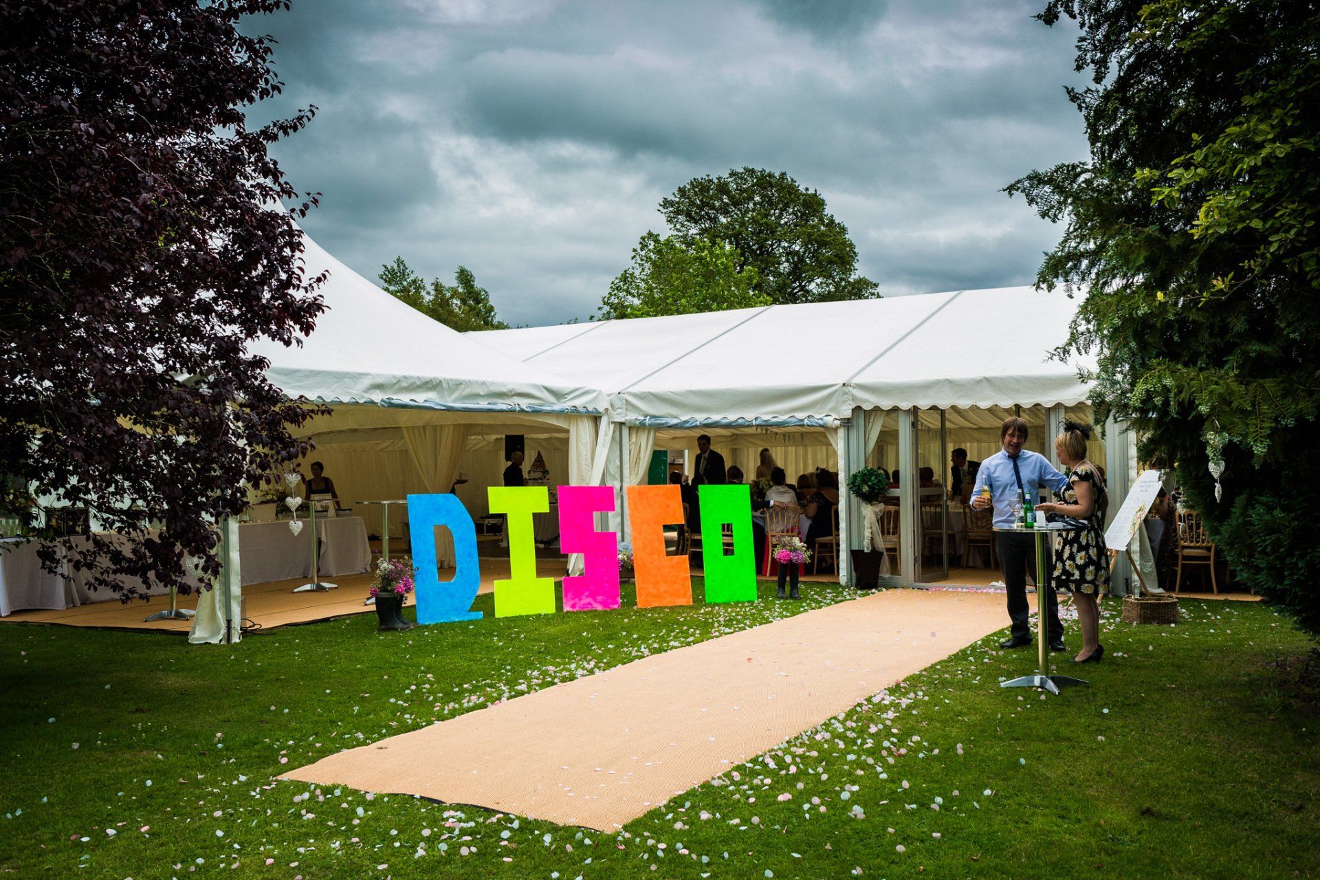 The word disco is written in neon letters on the grass