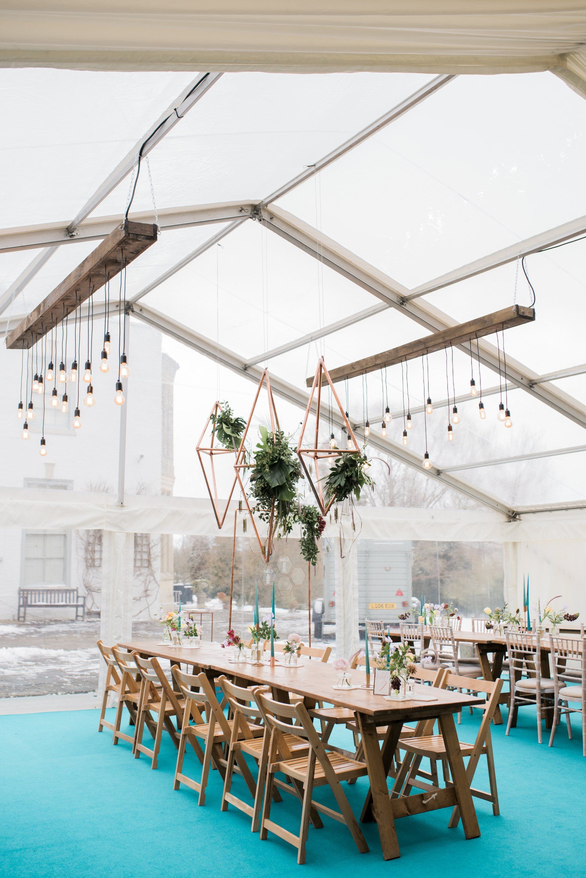 A long table and chairs under a clear tent.