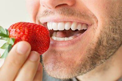 Man Eating Strawberries — Teeth Whitening in South Lawrence, MA Man Eating Strawberries — Teeth Whitening in South Lawrence, MA