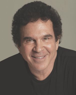 A man in a black shirt is smiling for the camera.