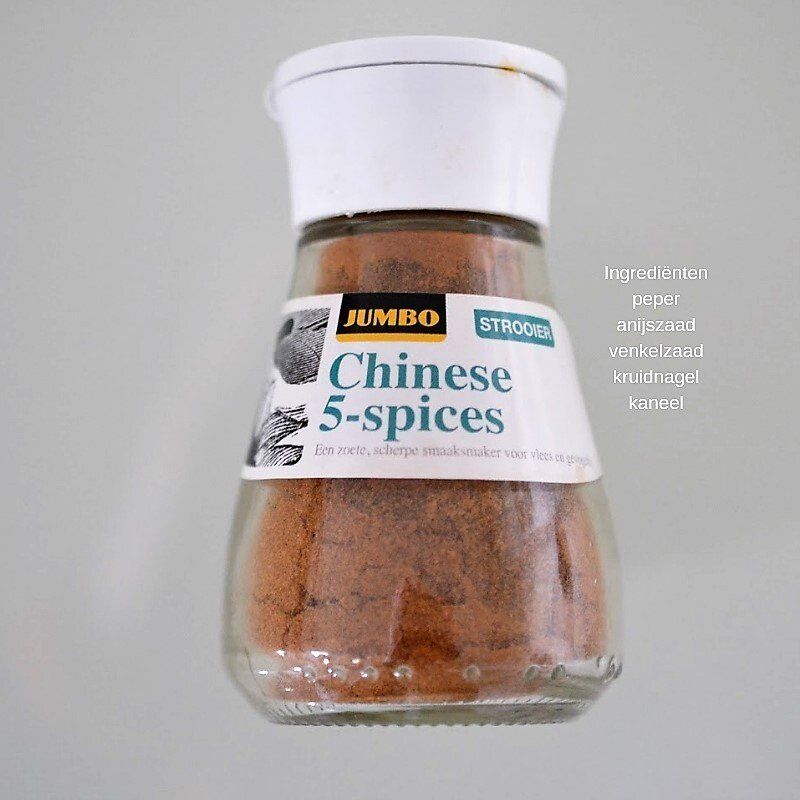 Verderop de pagina staat het recept Een pot Jumbo Chinese 5-kruidenmix, gevuld met bruin poeder, tegen een grijze achtergrond.